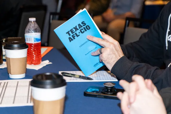 A convention attendee pages through a booklet of the Texas AFL-CIO Constitution.